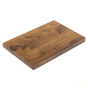 May include: A rectangular wooden cutting board with a rich, warm brown color. The wood grain is visible, adding texture and character to the surface. The board is likely made of a hardwood, suitable for food preparation.