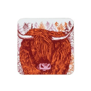 Puede incluir: Un primer plano de una ilustraci&oacute;n de vaca Highland roja y naranja sobre un posavasos blanco. La vaca est&aacute; de frente con sus cuernos visibles. El fondo es rosa claro y blanco con un bosque de &aacute;rboles.