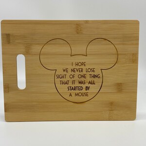 May include: A wooden cutting board with a Mickey Mouse silhouette and the text "I hope we never lose sight of one thing. That it was all started by a mouse."