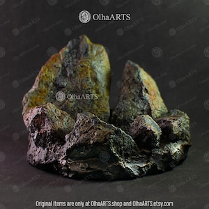 May include: A dark gray and green rock formation with a rough, textured surface. The rock formation is shaped like a mountain range with peaks and valleys. The rock formation is a decorative piece for a home or garden.