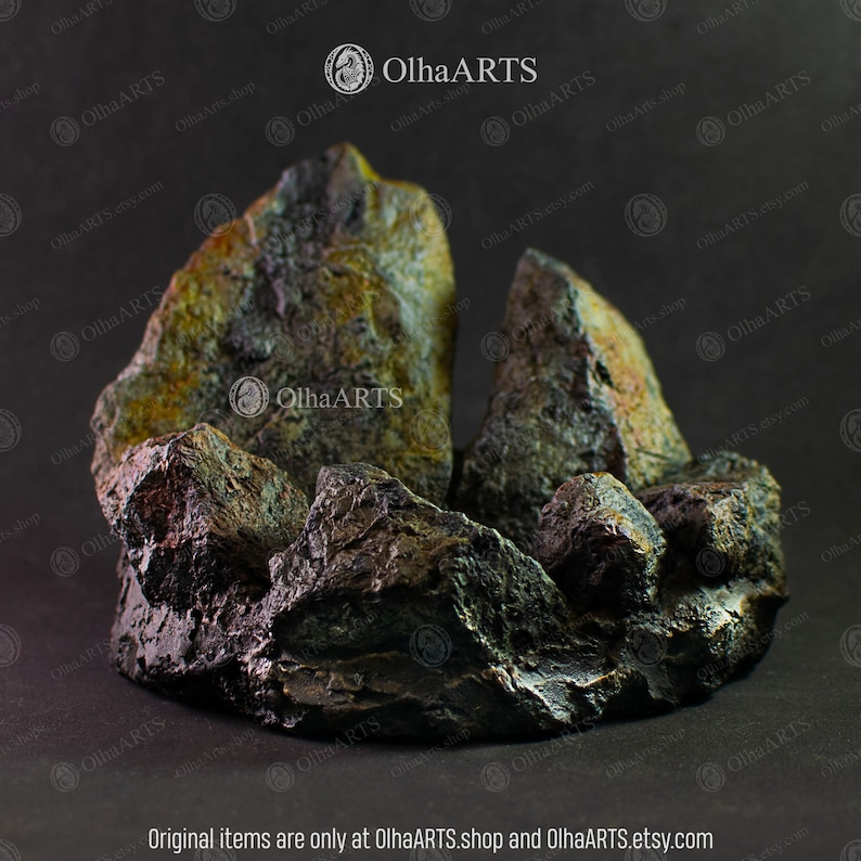 May include: A dark gray and green rock formation with a rough, textured surface. The rock formation is shaped like a mountain range with peaks and valleys. The rock formation is a decorative piece for a home or garden.