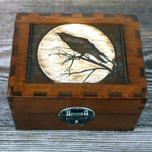 Engraved raven or crow  in front of a full moon wooden apothecary chest for potions or essential oil storage box with 12 glass bottles