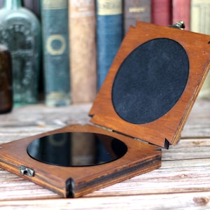 Obsidian scrying mirror in custom wooden holder for spiritual divination, 10cm round