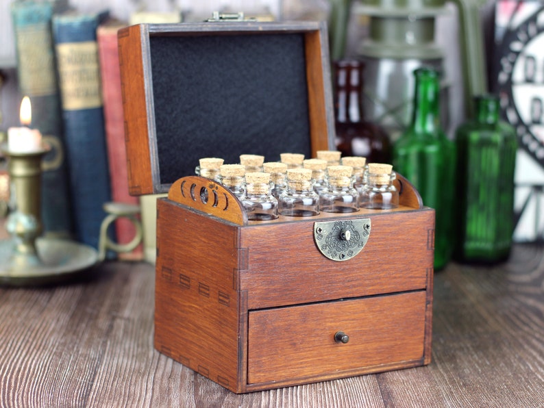 Handmade apothecary cabinet with drawer holding twelve bottles with corked lids.