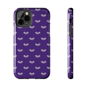 May include: A purple phone case with a repeating pattern of white eyelash designs. The case is shown from the front and side, highlighting its glossy finish and the camera cutout.