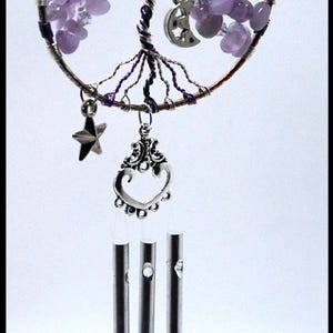 Op de afbeelding: Een paarse amethist draadgewikkelde levensboom windgong met een halve maan, ster en hart charme. De gong heeft drie zilveren buizen.