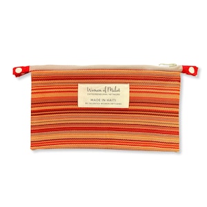 May include: A red and orange striped zippered pouch with a label that reads "Women of Milot Entrepreneurial Network Made in Haiti by Talented Women Artisans".