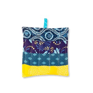 May include: A quilted hot pad with a blue, purple, and yellow geometric pattern. The hot pad has a loop for hanging.