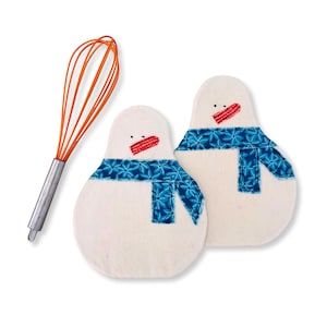May include: Two snowman-shaped pot holders with blue scarves and red stitched mouths. An orange whisk with a silver handle is to the left of the pot holders. The pot holders are white and are on a white background.
