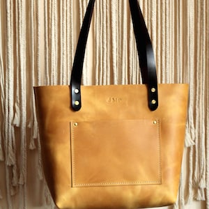 Customizable leather tote in three neutral colors: camel, chocolate, and slate grey