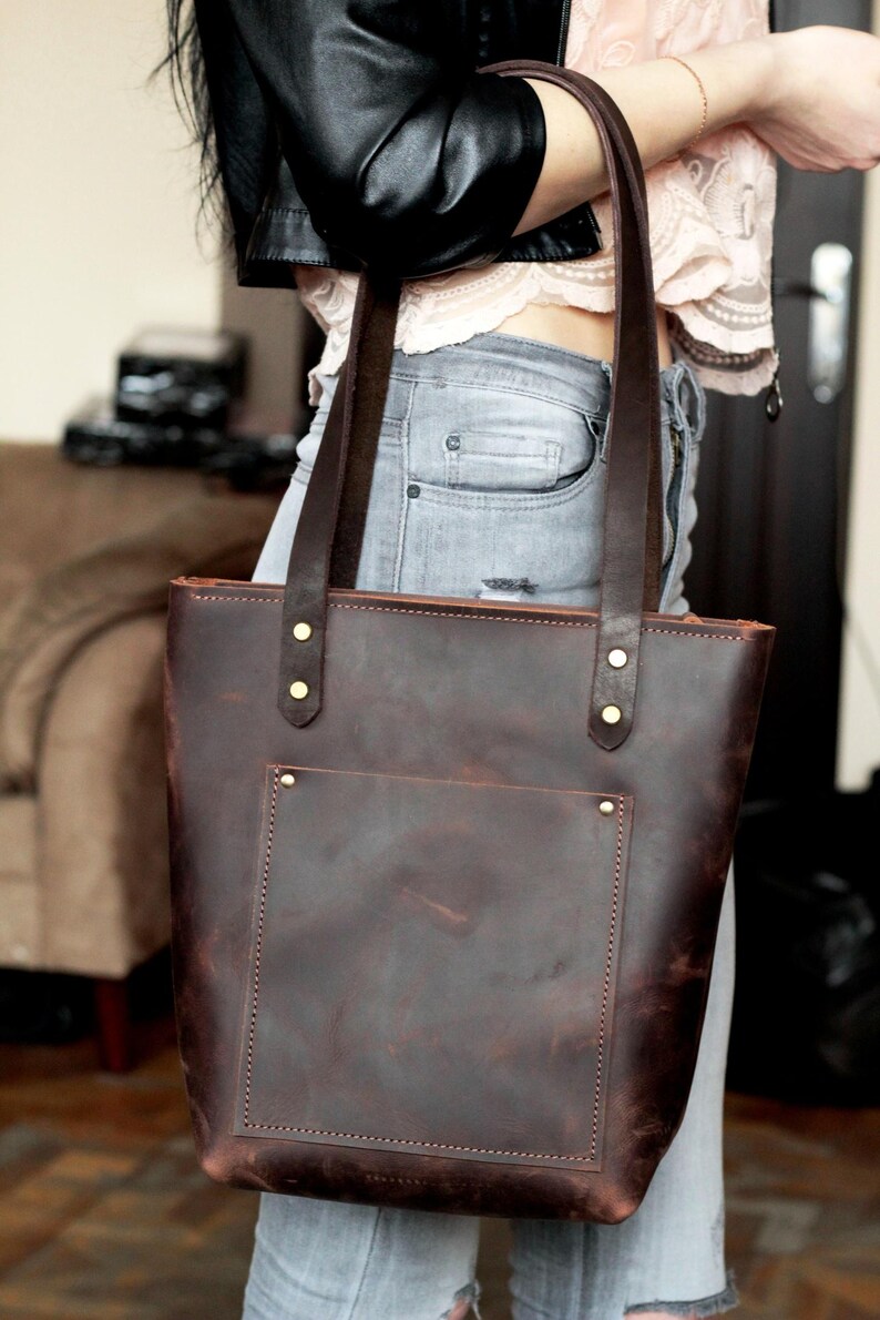 Personalized leather tote bag with a sleek, modern design and contrasting stitch detail.