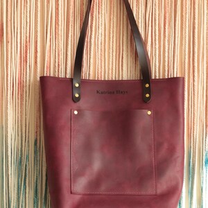 A monogrammed leather tote bag being used as a chic and practical diaper bag