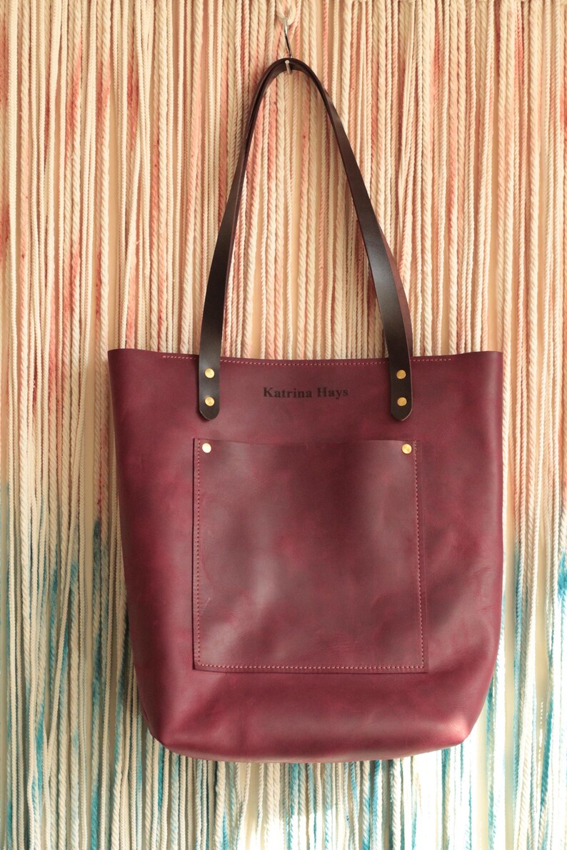 A monogrammed leather tote bag being used as a chic and practical diaper bag