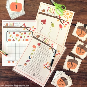 May include: A set of printable autumn-themed educational activities for children. The activities include a count and graph worksheet, a colour by number worksheet, a scissor skills worksheet, and a colour words worksheet. The worksheets feature autumn colours, leaves, pumpkins, acorns, and other autumn-themed imagery.