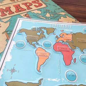 May include: A blue and white world map with continents and oceans labeled. The continents are cut out and can be moved around the map. The map includes the following labels: North America, South America, Europe, Africa, Asia, Pacific, Atlantic, Southern, and India.