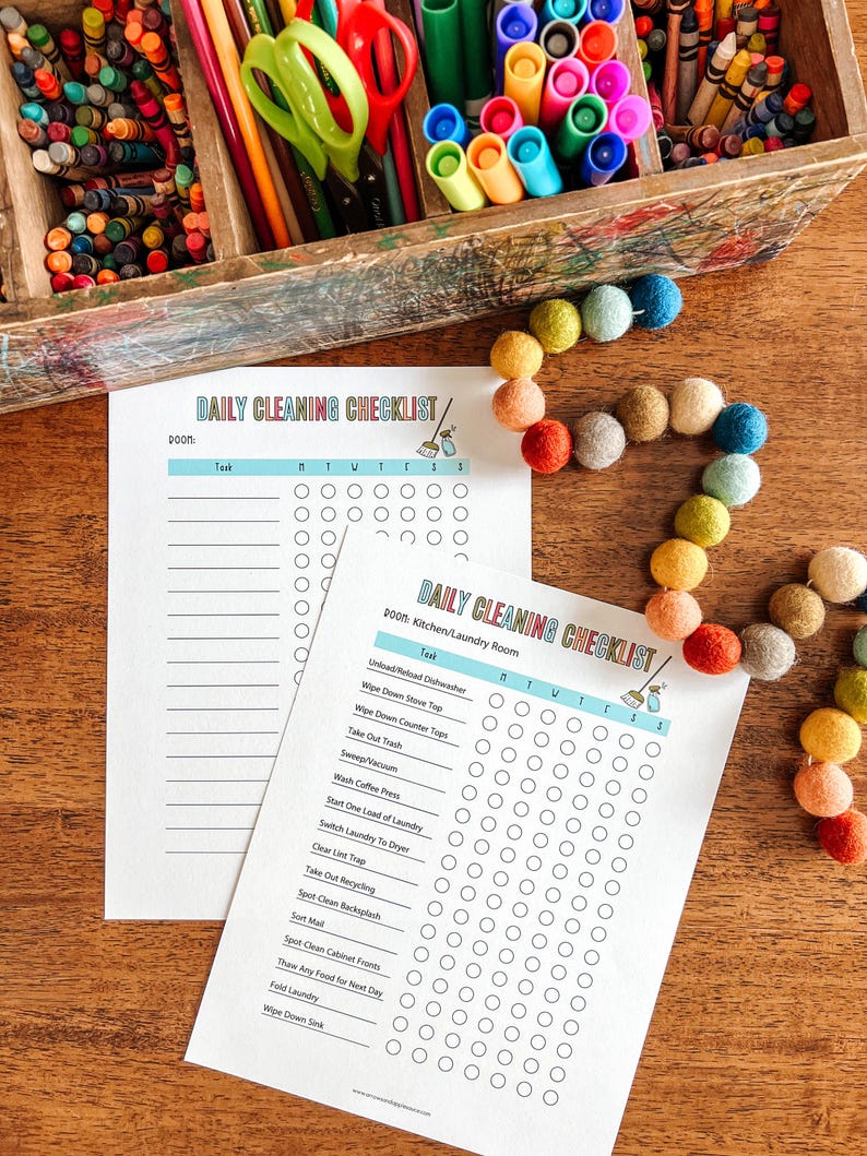 May include: A printable daily cleaning checklist with a colorful broom icon. The checklist is divided into two sections: "DOOM" and "2000: Kitchen/Laundry Room". Each section has a list of tasks with checkboxes for each day of the week.