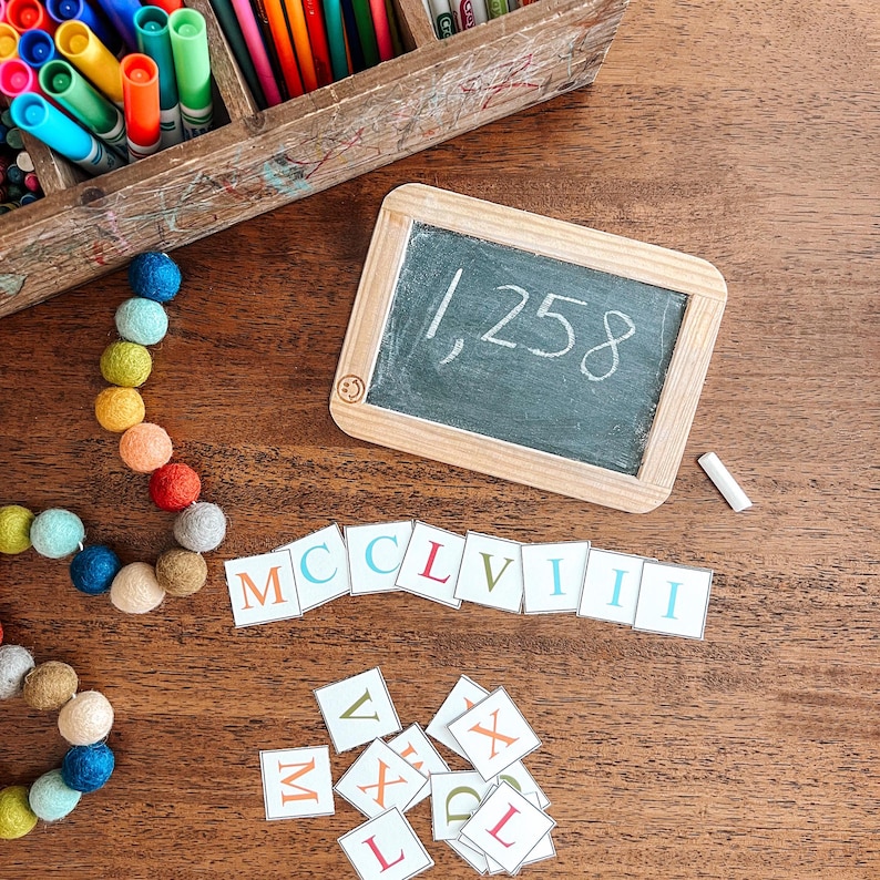 May include: A wooden chalkboard with the number 1,258 written on it. There are also letter tiles spelling out the Roman numeral for 1,258, which is MCCLVIII. There are also some colorful letter tiles scattered on a wooden surface.