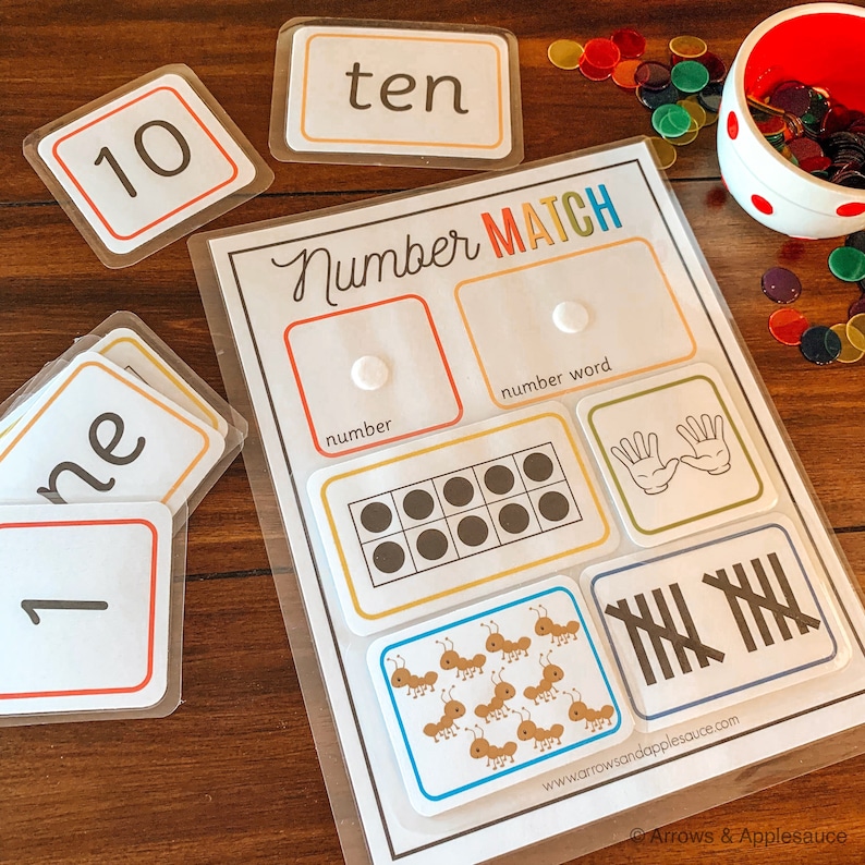 May include: A printable number matching game with cards featuring numbers, number words, tally marks, and pictures. The game is designed to help children learn to count and match numbers.