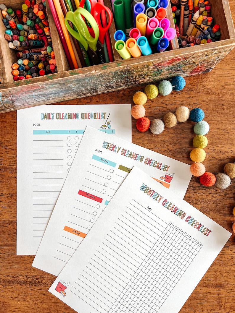 May include: Three printable cleaning checklists: daily, weekly, and monthly. Each checklist has a colorful design with a bucket and cleaning supplies. The checklists are printed on white paper and are ready to be used.