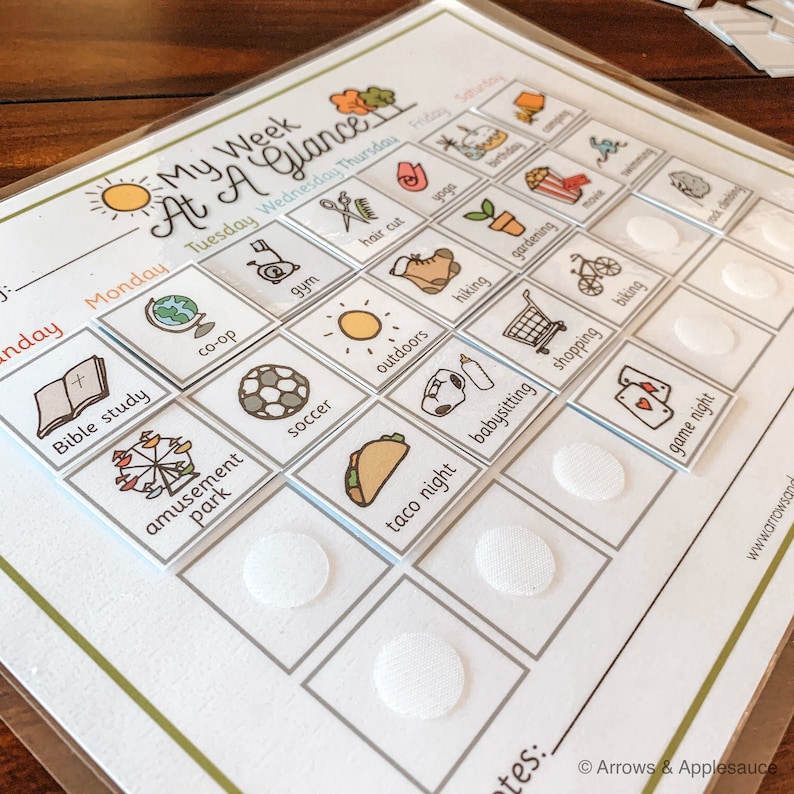 K&ouml;nnte beinhalten: Ein wei&szlig;es Trockenl&ouml;schboard mit einem Wochenplan f&uuml;r Kinder. Das Board hat ein farbenfrohes Design mit Bildern von Aktivit&auml;ten wie Fu&szlig;ball, Radfahren und Spielen. Das Board hat Klettpunkte zum Anbringen von Aktivit&auml;tskarten.