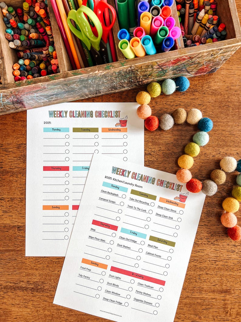 May include: Two printable weekly cleaning checklists with colorful headings and checkboxes. The checklists are titled "Weekly Cleaning Checklist" and "Weekly Cleaning Checklist: Kitchen/Laundry Room".