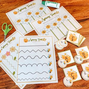 May include: A set of printable spring-themed educational worksheets for children. The worksheets feature counting, scissor skills, and letter matching activities with a bee and flower theme. The worksheets are printed on white paper with black ink.