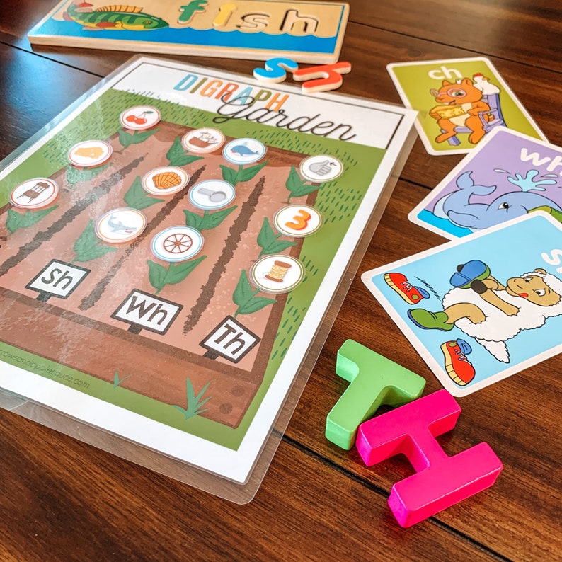 Puede incluir: Un juego educativo colorido para ni&ntilde;os con un jard&iacute;n de d&iacute;grafos que incluye im&aacute;genes de diferentes objetos y las letras 'sh', 'wh' y 'th'.