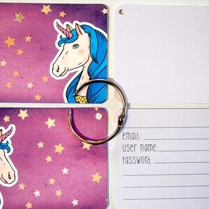 May include: A set of four purple cards with a unicorn illustration on each card. The cards are connected by a silver ring. The cards have a white background with gold stars. The last card has a white background with lines for writing email, user name, and password.