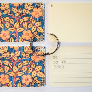 May include: A set of four yellow and cream colored index cards with a floral pattern on the front and blank on the back. The cards are attached together with a silver ring. The cards have tabs on the side with letters for alphabetizing. One card has the words "email", "user name", and "password" written on it.