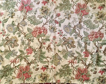 May include: A piece of off-white fabric featuring a repeating botanical pattern of large red flowers, muted green leaves, and brown branches. The design includes intricate floral details and small berries, with the text DOC 067B visible.