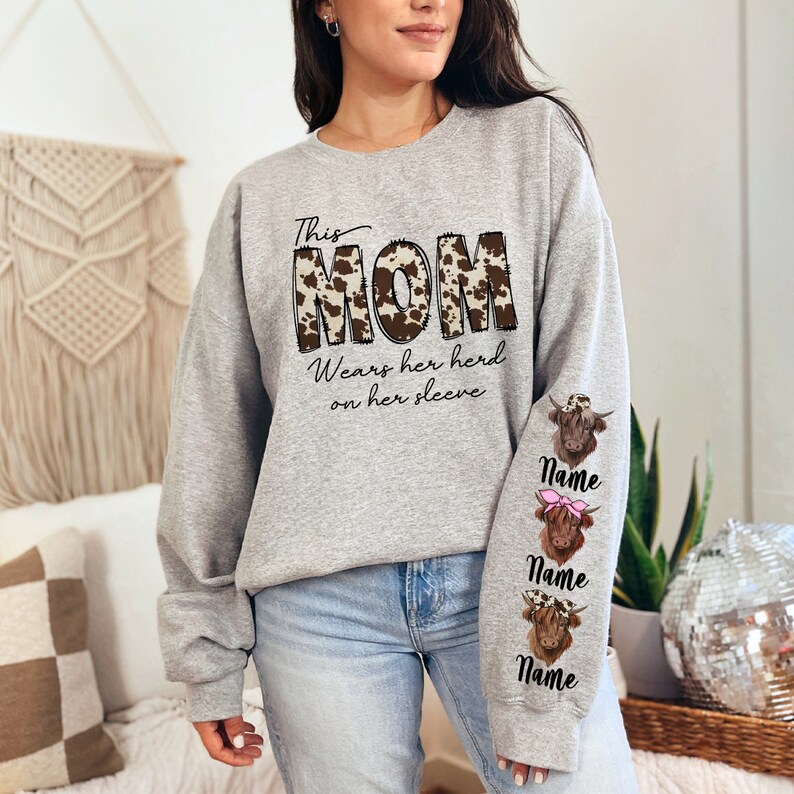 a woman standing in a room wearing a gray sweatshirt