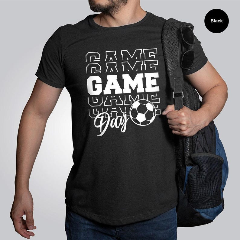 a man is holding a backpack and wearing a t - shirt
