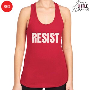 May include: Red tank top with the word "RESIST" printed in white on the front.