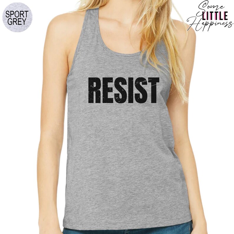 May include: A grey tank top with the word "RESIST" printed in black letters. The letters have a distressed, vintage look.