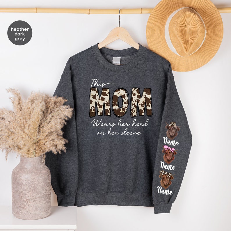 a sweater with the word mom on it next to a plant