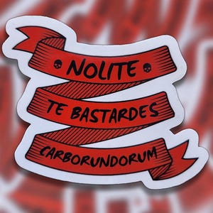 May include: Red and black sticker with a banner that reads "Nolite Te Bastardes Carborundum".