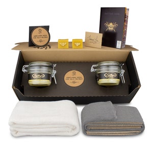 May include: A gift box set containing two jars of honey, two small bars of beeswax, a small bag of sunflower seeds, two cloths, and a thank you card. The box is open and the contents are visible. The jars of honey are labeled "Gilboy's Pure Gold". The sunflower seed bag says "Sunflower Seeds for You & The Bees".