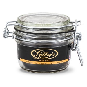 May include: A glass jar with a metal lid and a black label that reads "Gilboy's rose gold Rosewood - Light Mahogany - Cherry - Honey Oak".