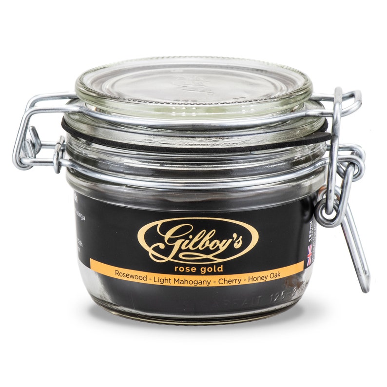 May include: A glass jar with a metal lid and a black label that reads "Gilboy's rose gold Rosewood - Light Mahogany - Cherry - Honey Oak".