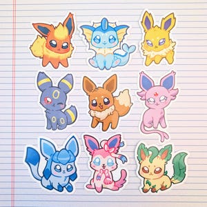 May include: Nine colorful cartoon stickers of various creatures, each with unique designs and colors. The stickers are on lined paper. The creatures include orange, blue, yellow, black, brown, pink, and green characters.