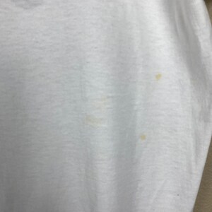 May include: White t-shirt with a few small yellow stains.