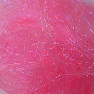 Könnte beinhalten: Nahaufnahme eines leuchtend rosa Materials mit flauschigem, strukturiertem Aussehen. Das Material hat eine schimmernde, irisierende Qualität, mit Strähnen aus silbernen oder weißen Fasern dazwischen. Der Gesamteffekt ist weich und optisch ansprechend.