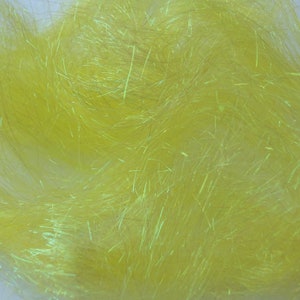 May include: Close-up of a pile of bright yellow, iridescent synthetic fibers. The fibers are thin and have a slightly textured appearance, with a subtle sheen. The fibers are densely packed, creating a soft, fluffy texture.