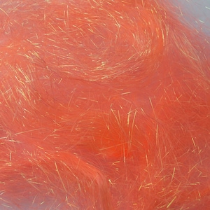 May include: Close-up of vibrant orange craft material with strands of gold and dark brown fibers. The fibers are densely packed and create a textured, fluffy appearance. The material has a soft, flowing quality, ideal for various crafting projects.