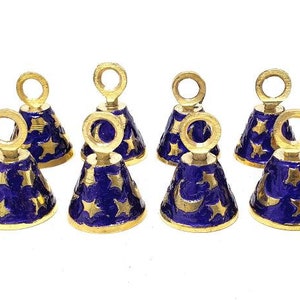 May include: Twelve small gold bells with blue enamel and gold stars and crescent moons. The bells have a loop at the top for hanging.
