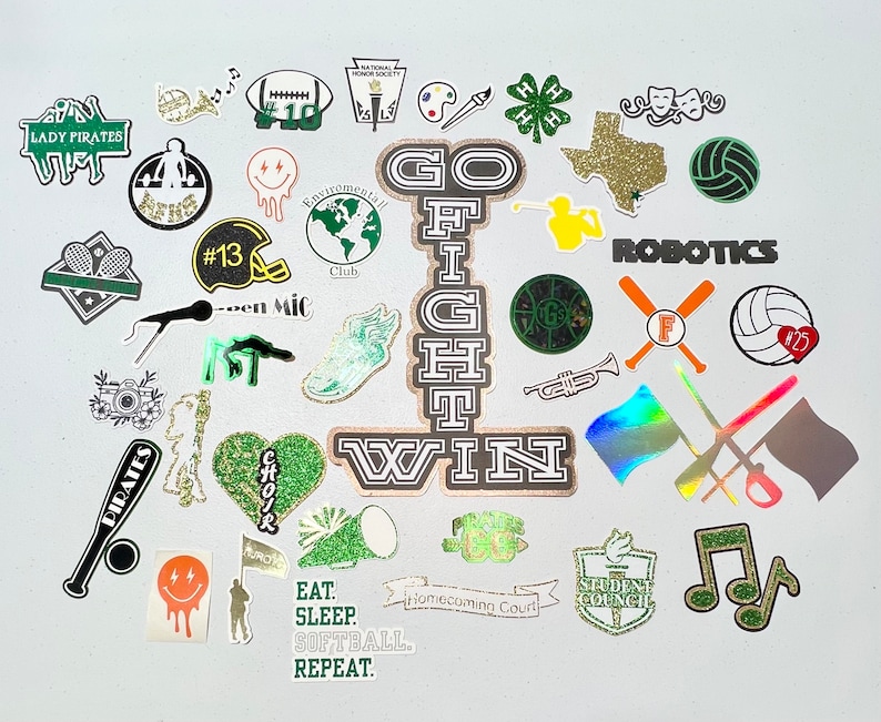 May include: A collection of green, gold, and black stickers with various designs, including a football, a trumpet, a microphone, a heart, a star, a clover, a musical note, a Texas state outline, a volleyball, a robot, a flag, a camera, a microphone, a school mascot, and the words "Go Fight Win".
