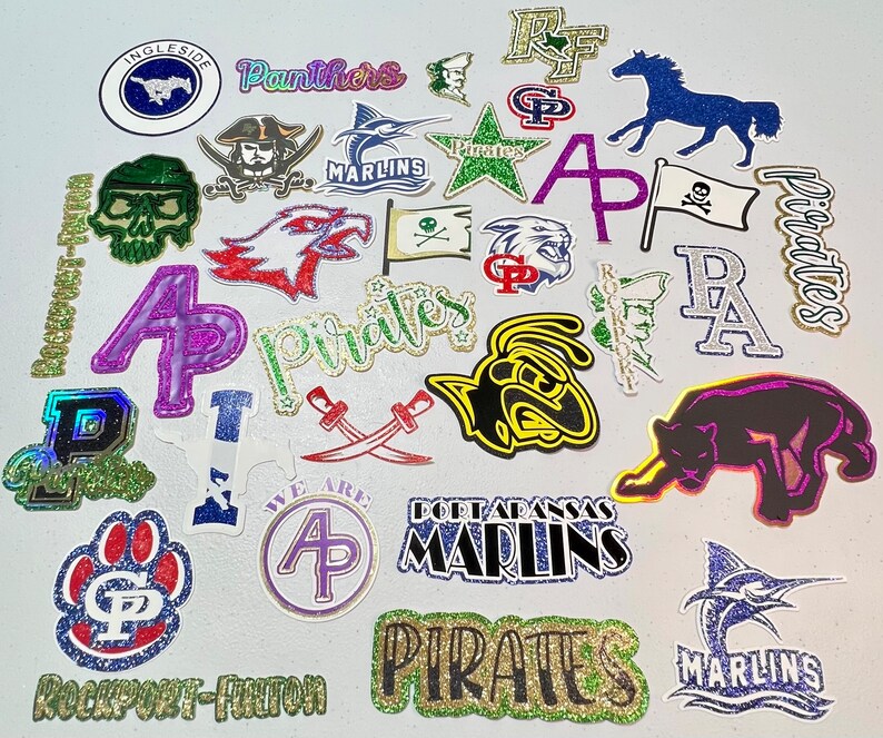 May include: A collection of colorful iron-on patches featuring various school mascots and logos, including pirates, panthers, and marlins. The patches are decorated with glitter and feature a variety of colors, including blue, green, red, gold, and purple.