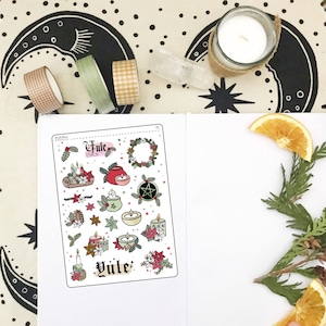 May include: A sheet of stickers with a Yule theme. The stickers feature illustrations of candles, wreaths, stars, and other winter solstice symbols. The text "Yule" appears twice on the sheet.