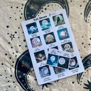 May include: A white sticker sheet titled Full Moons featuring twelve square illustrations of monthly lunar events, including a wolf, rabbit, and flowers, with a smaller rectangular sticker overlay showing seasonal blue and black moon designs.