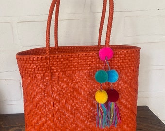 Oranje geweven plastic draagtas: duurzame strandtas met pomponkwastjes